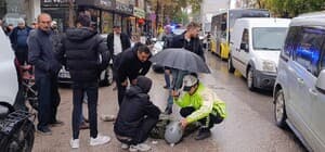 Kadın polis, yaralı ıslanmasın diye başında şemsiyeyle bekledi